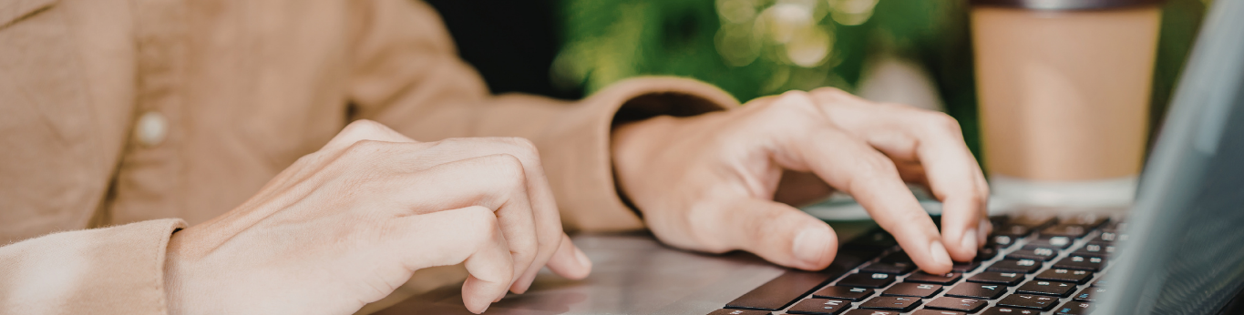 womens hands typing on a computer