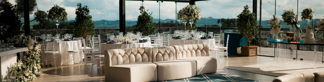 interior shot of an event venue set up with flowers, tables, and chairs