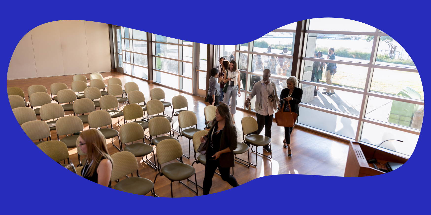 An interior shot of a well-maintained venue space set up with chairs, and event attendees entering through doors